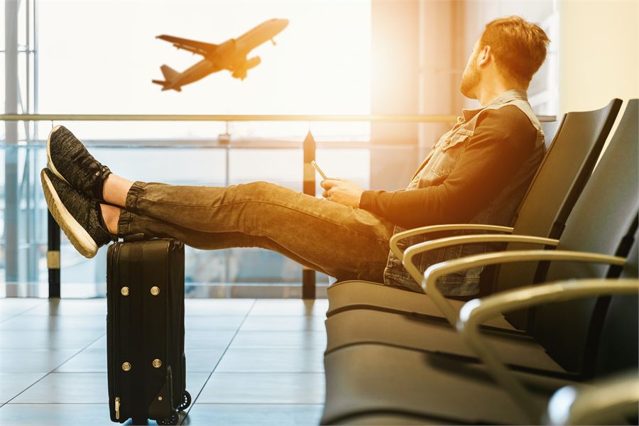 Traveller waiting at the airport as a plane takes off