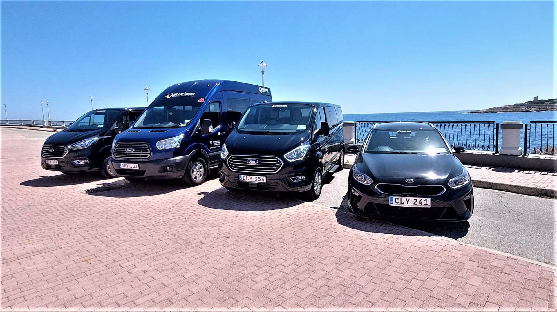 The Blue Bird fleet — saloon car, people carriers and minibus parked on the Maltese coast